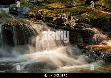 Kleiner Wasserfall, der über moosige Felsen im Wald an den Minnehaha Falls, Georgia, USA, fließt und mit langer Exposition aufgenommen wurde. Stockfoto