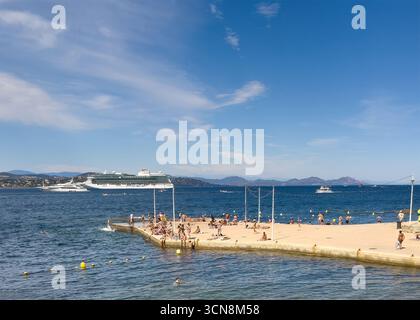 Saint Tropez, Frankreich - 13. Juli 2024: Landschaft in der Innenstadt. Pier von Plage de la Ponche mit mehreren Badern und Schiffen, groß und klein auf den Gewässern des Golfs u Stockfoto