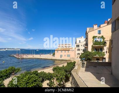 Saint Tropez, Frankreich - 13. Juli 2024: Landschaft in der Innenstadt. Pier von Plage de la Ponche mit den umliegenden Gebäuden, die überwiegend unter blauem Himmel wohnen. S Stockfoto