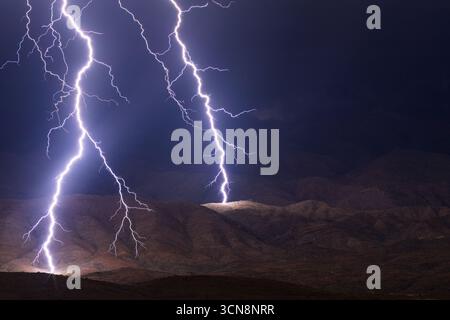 Dramatische Blitze treffen während eines Monsunsturms in Arizona auf einen Berg Stockfoto