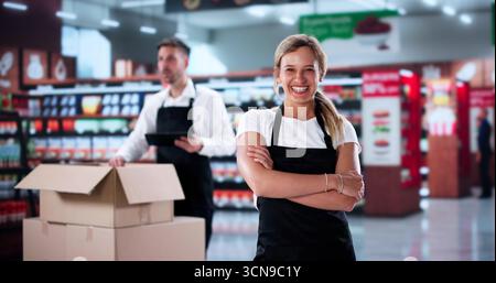 Das Retail Team Lächelt, Als Manager Beim Einkaufen In Einem Geschäftigen Geschäft Führt Stockfoto