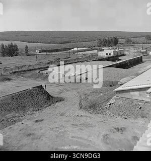 Ein historisches Foto aus den 1980er Jahren, das einen Panoramablick auf das Versorgungsgebiet der „Ukraine“ Kolchoz im Dorf Khrestyschche, ukrainische SSR zeigt. Im Vordergrund befinden sich große Betongräben, die als Düngerlagunen oder zur Silagelagerung genutzt werden, ein wichtiger Teil der Infrastruktur eines großen Viehkomplexes. Das Bild spiegelt die Größe und die industriellen Technologien in der Landwirtschaft des spätsowjetischen Donbass wider Stockfoto