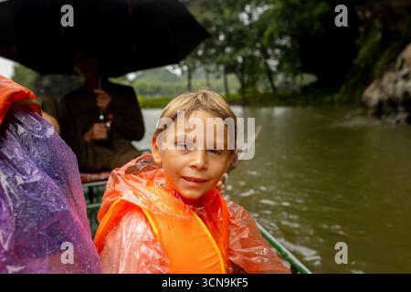 Europäische Familie, Besuch der Provinz Ninh Binh, Wandern, Radfahren und eine Bootsfahrt, Kind genießt Sommerurlaub in Vietnam Stockfoto