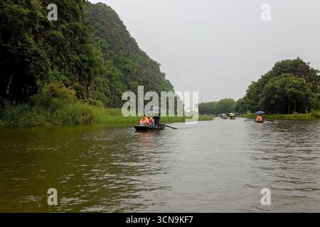 Europäische Familie, Besuch der Provinz Ninh Binh, Wandern, Radfahren und eine Bootsfahrt, Kind genießt Sommerurlaub in Vietnam Stockfoto