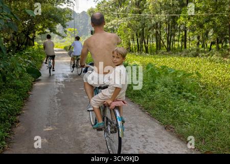 Europäische Familie, Besuch der Provinz Ninh Binh, Wandern, Radfahren und eine Bootsfahrt, Kind genießt Sommerurlaub in Vietnam Stockfoto