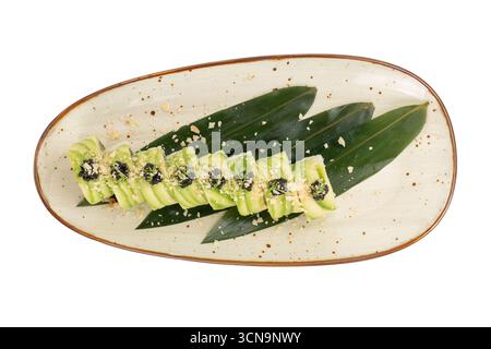 Avocado-Sushi-Rolle mit Tamago-Yaki und Garnelen auf einer langen Keramikplatte, isoliert auf weißem Hintergrund. Draufsicht. Stockfoto