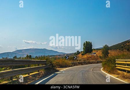 Scharfe Abbiegeschilder auf einer Bergstraße in Italien Stockfoto