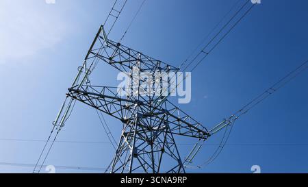 Power Pylon aus Stahlgitter mit Kabeln über Kopf Stockfoto