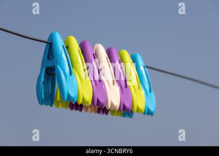 Bunte Kleiderschalen auf der Wäscheleine mit hellblauem Hintergrund. Stockfoto