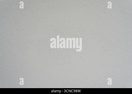 Weiße Verputzte Wand. Einfache weiße, verputzte Wand mit fein strukturierter Oberfläche. Minimalistischer Hintergrund für Design oder Fotografie. Stockfoto