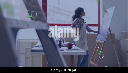 Maler in lackierter Schürze, die Leinwand im Atelier berührt, mit Pinseln, rotem Becher, Kopierraum Stockfoto