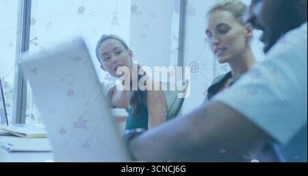 Mitarbeiter, die gemeinsam arbeiten, teilen Ideen im Besprechungsraum mit Netzwerksymbolen für Notebooks mit Notebook-Stiften Stockfoto