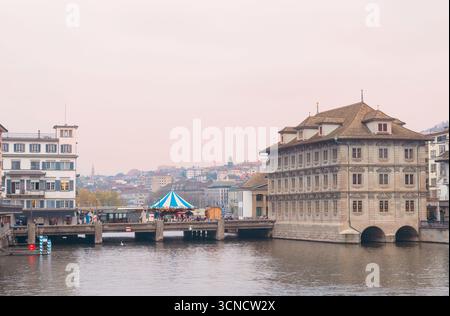 Zürich Schweiz - 20. Oktober 2022: Das Rathaus Zürich steht an der Limmat, mit der Rathausbrücke, der Fußgängerbrücke, über den Fluss. Stockfoto