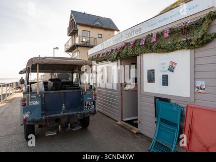 Vintage Land Rover vor dem East Beach Coffee Stop auf der Promenade in Sheringham an der Küste von Norfolk Stockfoto