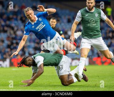 Glasgow, Großbritannien. September 2025. Der Rangers FC spielte im Ibrox Stadion in Glasgow in einem Premier Sports Cup-Spiel Hibernian FC. Das Ergebnis war Rangers 2:0 Hibernian. Thelo Aasgaard (R11) und Rocky Bushiri (H33) stoßen zusammen, als Grant Hanley (H4) vorbeifährt. Quelle: Findlay/Alamy Live News Stockfoto
