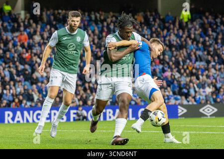 Glasgow, Großbritannien. September 2025. Der Rangers FC spielte im Ibrox Stadion in Glasgow in einem Premier Sports Cup-Spiel Hibernian FC. Das Ergebnis war Rangers 2:0 Hibernian. Rocky Bushiri (H33) und Nicolas Raskin (R43) kämpfen um den Ball. Credit: Findlay/Alamy Live News Stockfoto