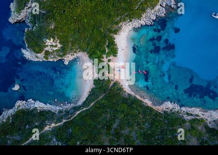 Detaillierte Dröhnen-Ansicht der Porto Timoni Isthmus in Korfu, Griechenland, mit Kajaks am Strand und dem unglaublichen Kontrast zwischen den beiden tur Stockfoto