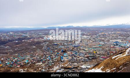 Panoramablick auf die Stadt Petropavlovsk-Kamtschatski von Mischnennaya sopka am bewölkten Frühlingsabend, Region Kamtschatka, Russland Stockfoto