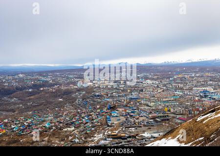 Blick auf die Stadt Petropavlovsk-Kamtschatski von Mischnennaya sopka am bewölkten Frühlingsabend, Region Kamtschatka, Russland Stockfoto