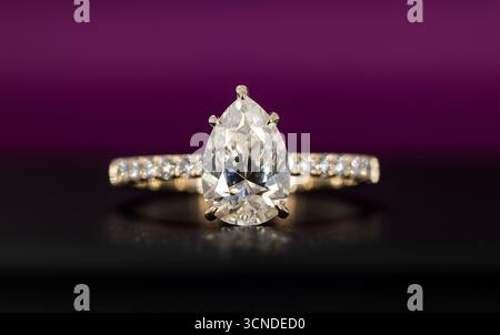 Ein Ring aus Gold und Diamant mit einem Diamanten in der Mitte. Der Ring ist auf schwarzem Hintergrund Stockfoto