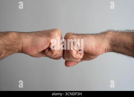 Männliche Hände in Faustgeste. Symbol für Vertrauen, Geschäftserfolg und gegenseitige Unterstützung. Stockfoto
