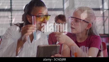 Der Lehrer, der einen Labormantel trägt, der ein Reagenzglas im Wissenschaftslabor hält, zeigt mit dem Schüler Stockfoto
