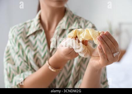 Schöne Frau mit Scrunchies im Schlafzimmer, Nahaufnahme Stockfoto