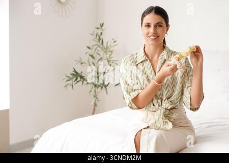Schöne Frau mit Scrunchies im Schlafzimmer Stockfoto