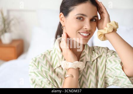 Schöne Frau mit Scrunchies im Schlafzimmer, Nahaufnahme Stockfoto