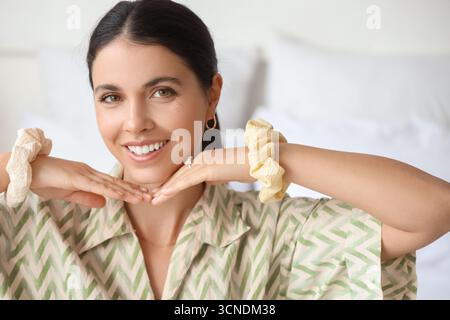 Schöne Frau mit Scrunchies im Schlafzimmer, Nahaufnahme Stockfoto