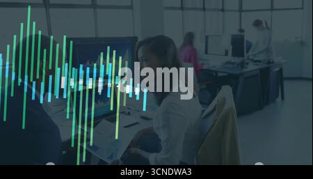 Analysten mit gedrucktem Bericht sitzen oben am Schreibtisch und Monitore zeigen Diagramme an Stockfoto