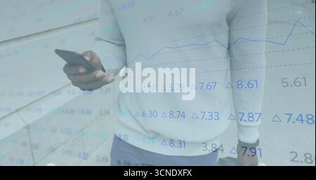 Smartphone halten und Koffer greifen, Geschäftsmann steht mit finanzieller Überlagerung an einer Steinmauer Stockfoto