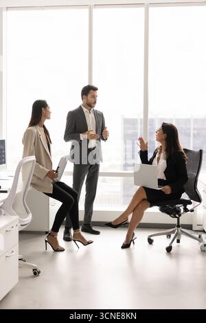 Ein dreiköpfiges Business-Team bespricht den Plan für den Tag Stockfoto