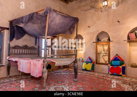 Oman - Nakhal - Nakhal Fort - Himmelbett und farbenfrohe Kissen in einem kühlen Gipsraum Stockfoto