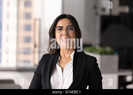 Selbstbewusste Geschäftsfrau in stilvoller Brille mit Blick auf die Kamera Stockfoto