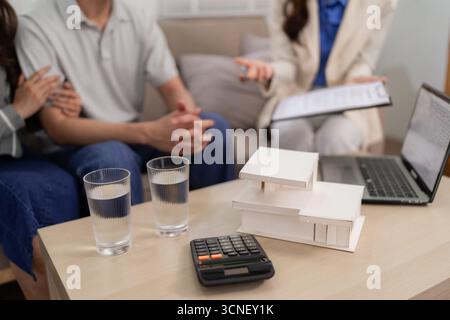 Asiatischer Immobilienberater erklärt Immobilieninvestitionen für Erwachsene Ehepaare zu Hause und diskutiert die Finanzplanung für zukünftige Hypotheken Stockfoto