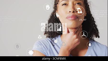 Berührende Frau mit blauem T-Stück, die Umweltsymbole und Code im Studio analysiert, im Kopierraum Stockfoto