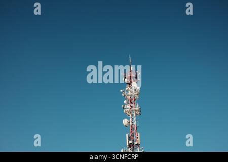 Kommunikationsturm mit Antennen gegen klaren blauen Himmel im Nationalpark Fruska Gora, Serbien. Stockfoto