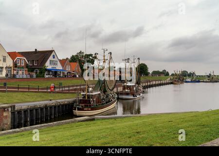 Greetsiel, Deutschland - 26. Juni 2025: Blick auf die historischen Backsteinhäuser und den Hafen von Greetsiel mit traditionellen Fischerbooten Stockfoto
