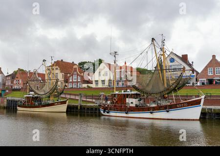 Greetsiel, Deutschland - 26. Juni 2025: Blick auf die historischen Backsteinhäuser und den Hafen von Greetsiel mit traditionellen Fischerbooten Stockfoto
