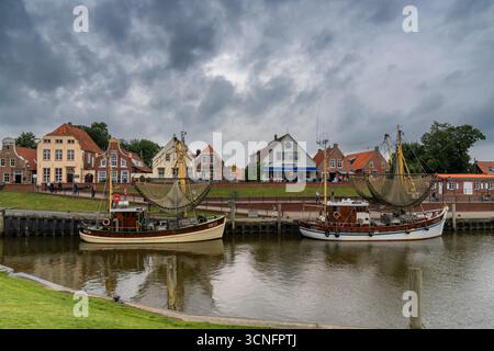 Greetsiel, Deutschland - 26. Juni 2025: Blick auf die historischen Backsteinhäuser und den Hafen von Greetsiel mit traditionellen Fischerbooten Stockfoto