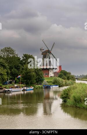 Greetsiel, Deutschland - 26. Juni 2025: Traditionelle ostfriesische Windmühlen an den Kanälen von Greetsiel an der Wattenmeerküste Deutschlands Stockfoto