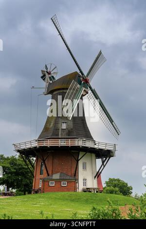 Greetsiel, Deutschland - 26. Juni 2025: Traditionelle ostfriesische Windmühle an den Kanälen von Greetsiel an der Wattenmeerküste Deutschlands Stockfoto