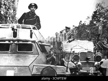 Adolf Hitler grüßt Soldaten aus seinem Mercedes. Im Vordergrund steht ein Panzerwagen SdKfz 222, 1939 Stockfoto