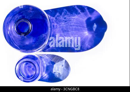 Draufsicht von zwei blauen Glasvasen, die blaue Reflexion auf weißem Hintergrund ausstrahlen Stockfoto