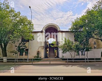 Die Fassade eines historischen Wohnhauses mit charakteristischem Hochbogentor und einer Außentreppe zum zweiten Stock. Stockfoto