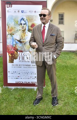 Lucca, Italien. September 2025. Lucca, 21. September 2025. Der US-amerikanische Schauspieler Kevin Spacey, gekleidet in einem beigefarbenen Anzug, einem weißen Hemd und einer roten Krawatte, kommt für den Fotoanruf im San Micheletto-Komplex an. Im Bild: Kevin Spaceys Fotoruf auf dem Rasen im San Micheletto Complex. Quelle: Unabhängige Fotoagentur/Alamy Live News Stockfoto
