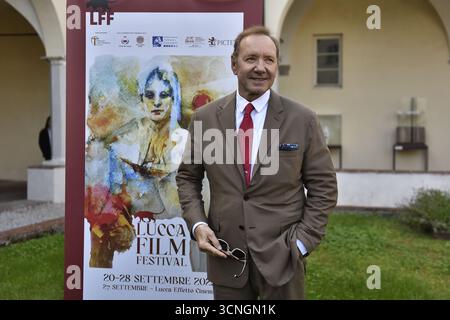 Lucca, Italien. September 2025. Lucca, 21. September 2025. Der US-amerikanische Schauspieler Kevin Spacey, gekleidet in einem beigefarbenen Anzug, einem weißen Hemd und einer roten Krawatte, kommt für den Fotoanruf im San Micheletto-Komplex an. Im Bild: Kevin Spaceys Fotoruf auf dem Rasen im San Micheletto Complex. Quelle: Unabhängige Fotoagentur/Alamy Live News Stockfoto