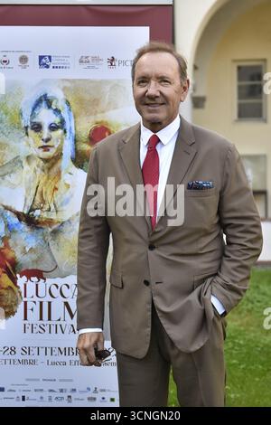 Lucca, Italien. September 2025. Lucca, 21. September 2025. Der US-amerikanische Schauspieler Kevin Spacey, gekleidet in einem beigefarbenen Anzug, einem weißen Hemd und einer roten Krawatte, kommt für den Fotoanruf im San Micheletto-Komplex an. Im Bild: Kevin Spaceys Fotoruf auf dem Rasen im San Micheletto Complex. Quelle: Unabhängige Fotoagentur/Alamy Live News Stockfoto