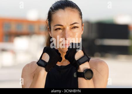 Porträt einer jungen Frau in Kampfstellung, bereit für das Schattenboxen draußen Stockfoto